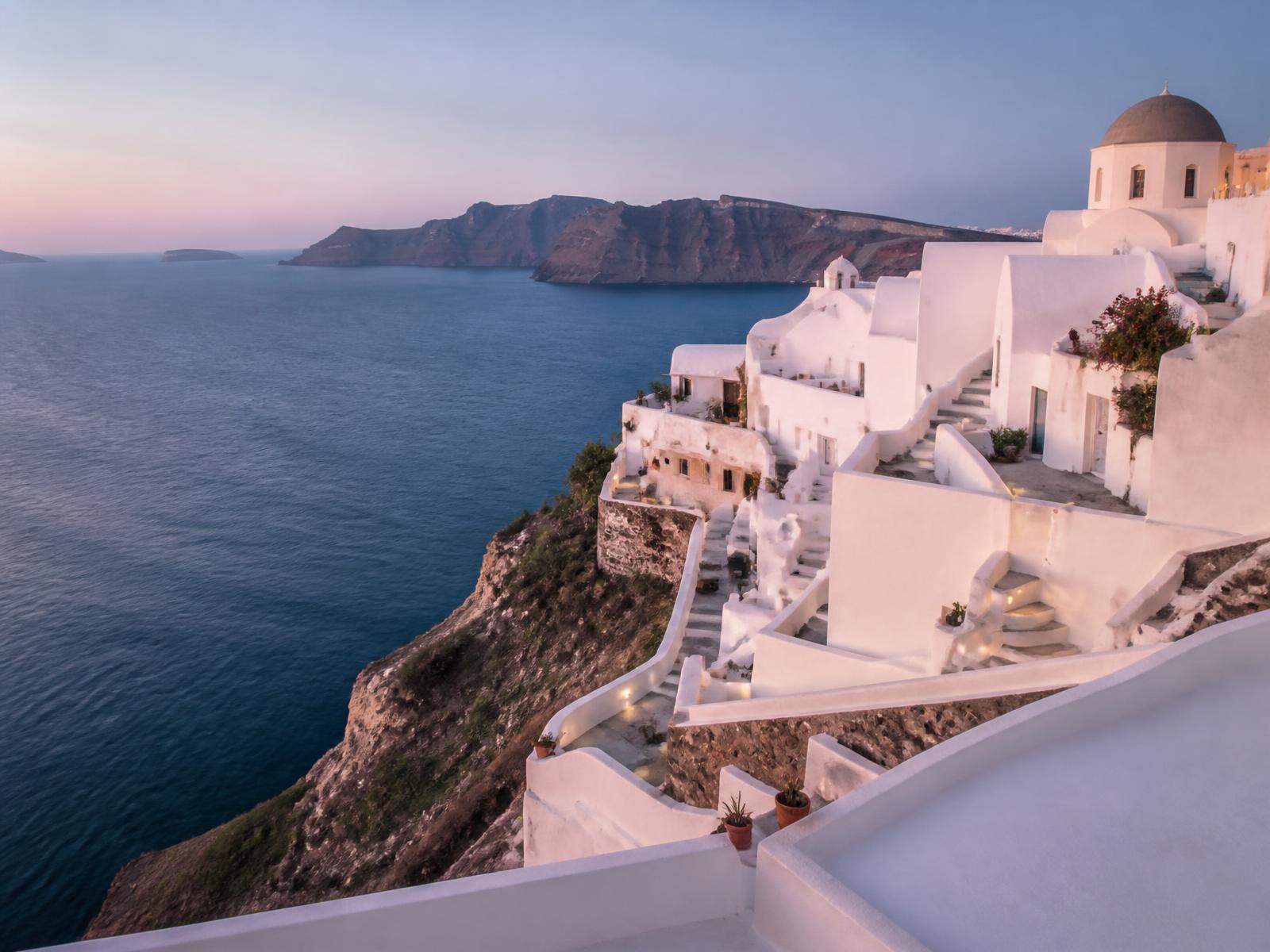 Whitewashed Mediterranean coastal architecture above the sea at dusk